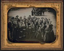 Large group of school children, with their teacher, standing in a town street, ca. 1850s. Creator: Unknown