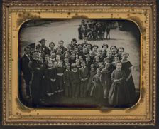 Large group of school children, with their teacher, standing in a town street, ca. 1850s. Creator: Unknown
