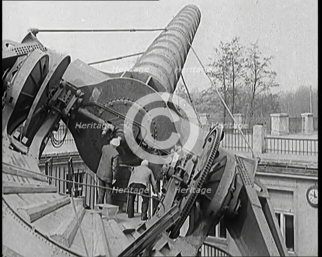 Large Telescope Being Turned by Two Civilians, 1931. Creator: British Pathe Ltd.