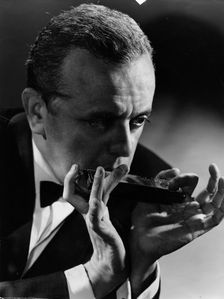Larry Adler (1914-2001), Musician, playing his harmonica, c1940s. Creator: Unknown