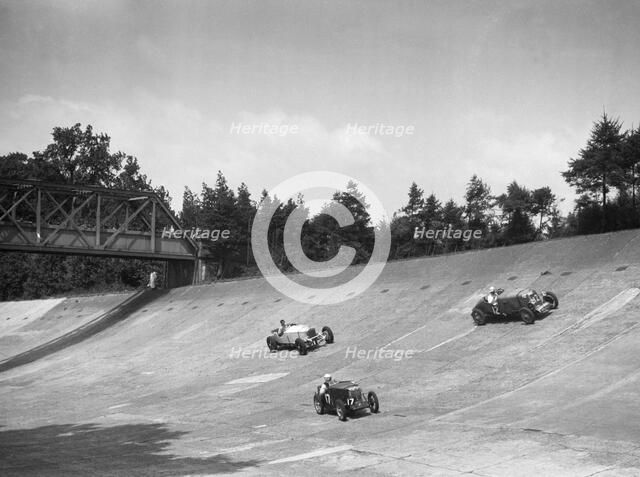 Lea-Francis 1496 cc, MG M type and Invicta 4467 cc racing on the Members Banking at Brooklands. Artist: Bill Brunell.