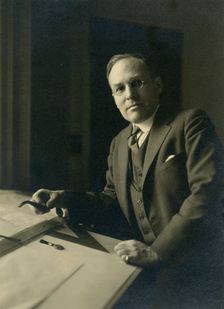 Leicester B. Holland, Chief of Fine Arts Division, Library of Congress posed...table, (1930?). Creator: Frances Benjamin Johnston