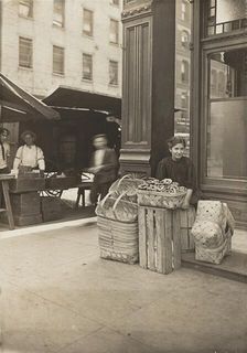 Lena Lochiavo - 11 years old, basket (and pretzel) seller, at Sixth Street Market in front of saloon Creator: Lewis Wickes Hine