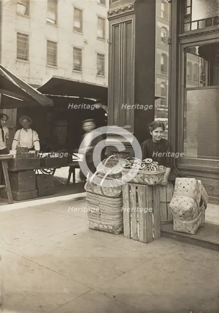 Lena Lochiavo - 11 years old, basket (and pretzel) seller, at Sixth Street Market in front of saloon Creator: Lewis Wickes Hine.