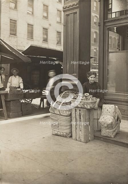 Lena Lochiavo - 11 years old, basket (and pretzel) seller, at Sixth Street Market in front of saloon Creator: Lewis Wickes Hine.