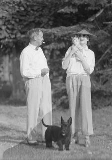 Leonard, Mr. and Mrs., with cat and dog, standing outdoors, between 1926 and 1938. Creator: Arnold Genthe