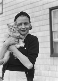 Leonard, Mrs., with cat, standing outdoors, between 1926 and 1938. Creator: Arnold Genthe