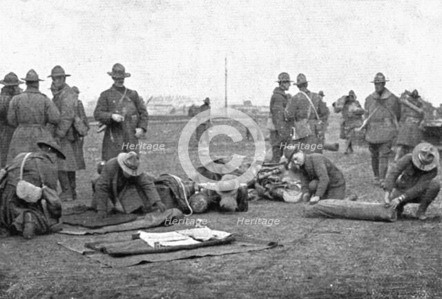 'Les Americains en Ligne; Le paquetage est roule a la descente du train', 1917. Creator: Unknown.