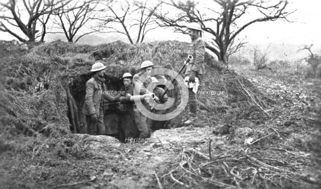 'Les Americains en Ligne; Une piece de 75, sous son camouflage, et ses servants americains', 1917 . Creator: Unknown.