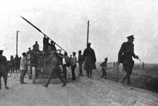 Les Fuyards; Un auto camion emportant des soldats avec un drapeau est evacué par..., 1917. Creator: Unknown