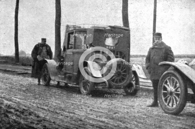 'Les hasards du service d'etat-major; Une voiture de secours va prendre en remorque la "blessee", do Creator: Unknown.