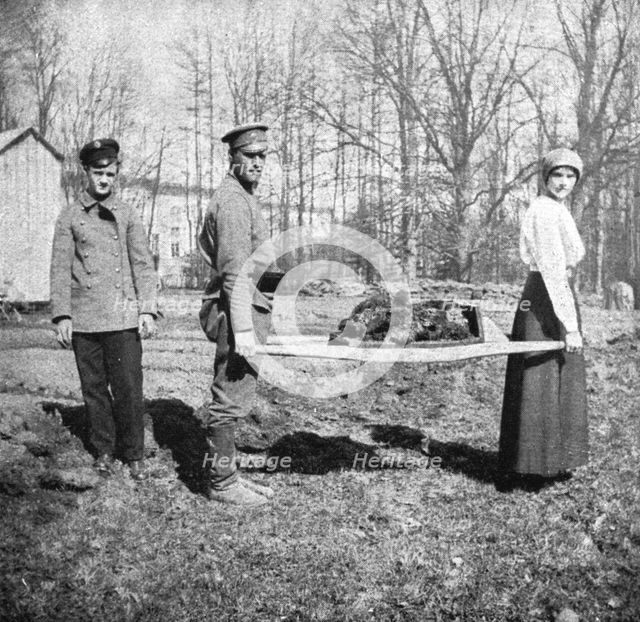 ''Les Romanof a Tsarskoie-Selo; La grande-duchesse Tatiana, aidee d'un soldat..., 1917. Creator: Unknown.