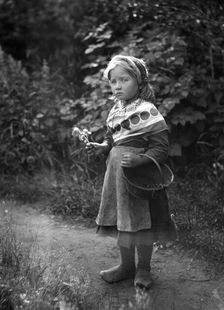 Little girl with basket and flowers in hands, 1898-1900. Creator: Johan Severin Nilson
