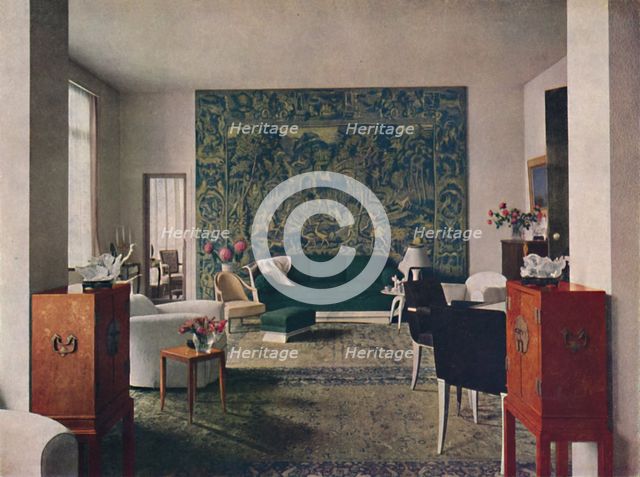 'Living-room designed by Porteneuve & Dominique, the end wall of which is hung with an old tapestry  Artist: Unknown.