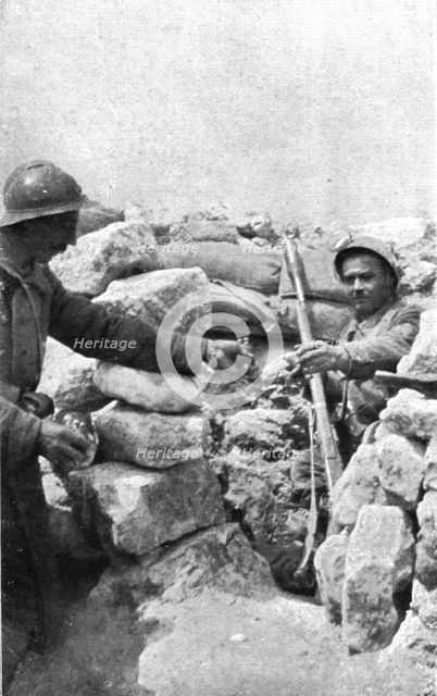 Life in the trenches in Champagne; A lookout 'teased' by the enemy is passed hand grenades, 1917. Creator: Unknown.