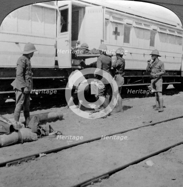 Lifting wounded soldiers onto a hospital train, East Africa, World War I, 1914-1918.Artist: Realistic Travels Publishers