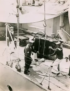 Lifting a case from the deck of H.M.S. Suffolk at Portsmouth, July 1935. Creator: Topical Press Agency