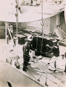 Lifting a case from the deck of H.M.S. Suffolk at Portsmouth, July 1935. Creator: Topical Press Agency