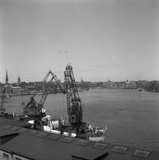 Lifting cranes at the city courtyard, Stockholm harbour, Sweden, 1950. Creator: Unknown