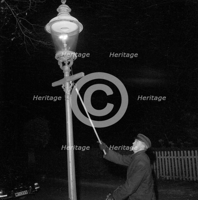 Lighting a gas lantern. Landskrona, Sweden, 1956. Artist: Unknown