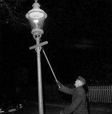 Lighting a gas lantern. Landskrona, Sweden, 1956. Creator: Unknown