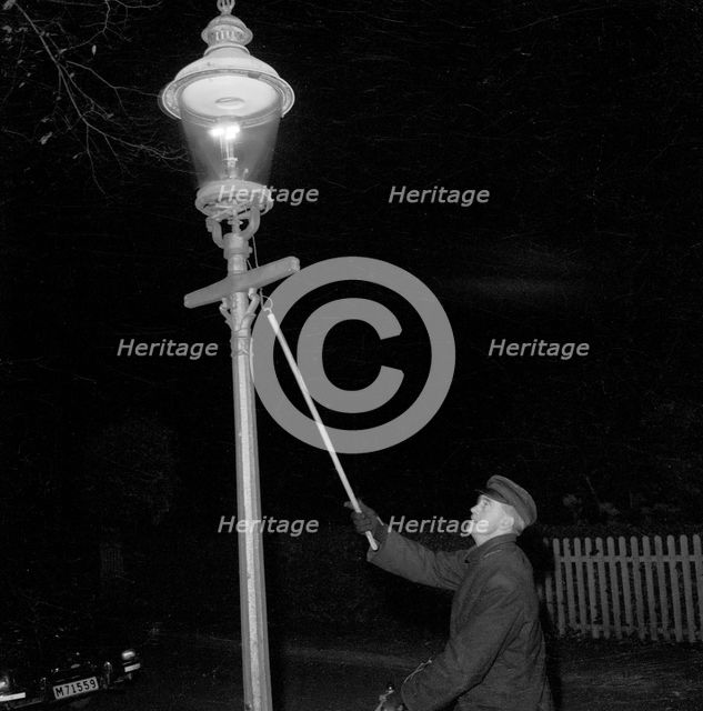 Lighting a gas lantern. Landskrona, Sweden, 1956. Creator: Unknown.