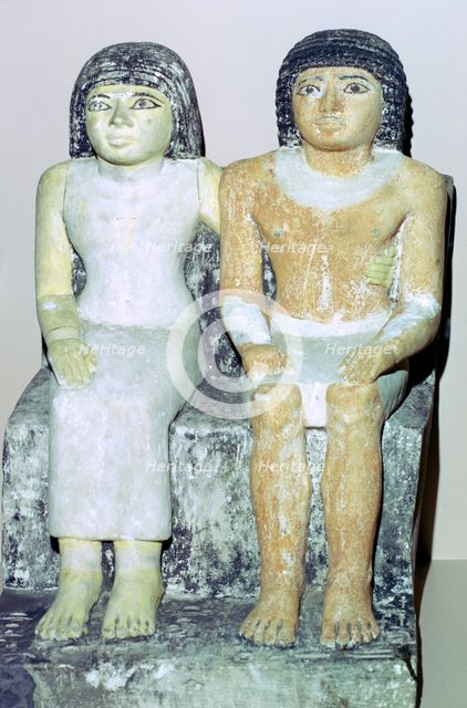 Limestone Egyptian statue of a man and his wife. Artist: Unknown