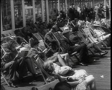 Lines of Men and Women Sitting in Deckchairs on a Pier at Brighton With Several Reading..., 1939. Creator: British Pathe Ltd