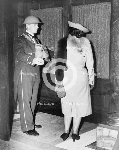 Linkman at the Trocadero wearing a tin hat, Westminster, London, October 1940. Artist: Unknown
