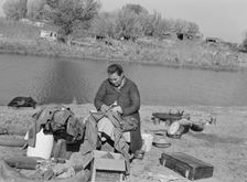 Mother of migrant family sewing, near Vale, Malheur County, Oregon, 1939. Creator: Dorothea Lange