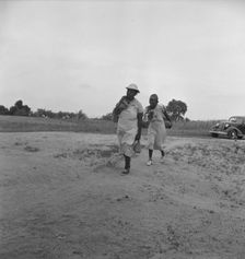 Mother of sharecropper family and friend...in the rain, Person County, North Carolina, 1939. Creator: Dorothea Lange