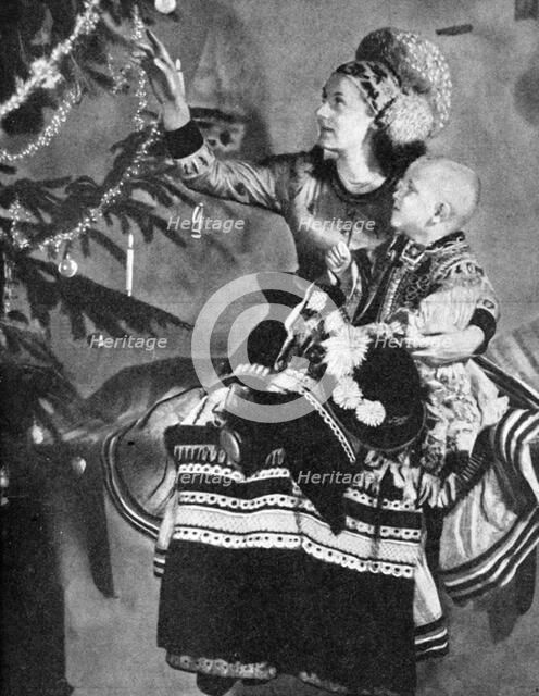 Mother and child with Christmas tree, Matyo people, Miskole, Hungary, 1936. Artist: Unknown