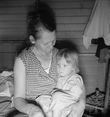 Mother from Oklahoma, awaits visit of resident nurse for sick baby, FSA camp, Farmersville, CA, 1939 Creator: Dorothea Lange