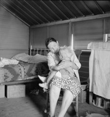 Mother from Oklahoma tends baby with dysentery, FSA camp, Tulare County, CA, 1939. Creator: Dorothea Lange