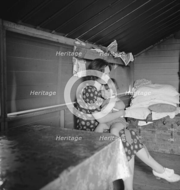 Mother with sick baby awaits arrival of FSA camp resident nurse, Tulare County, CA, 1939. Creator: Dorothea Lange.