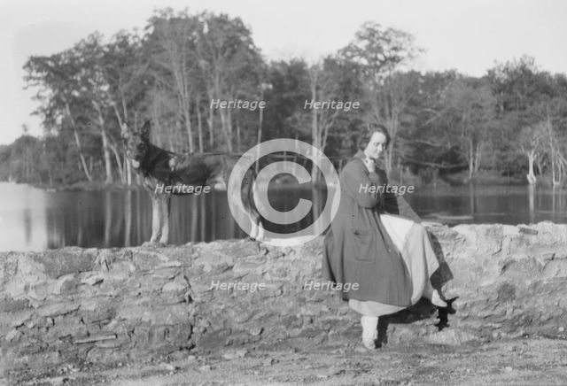 Mower, Margaret, Miss, with dog, seated outdoors, not before 1916. Creator: Arnold Genthe.