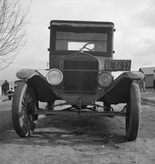 Model T Fords still carry migrants, FSA migratory labor camp at Farmersville, California , 1939. Creator: Dorothea Lange