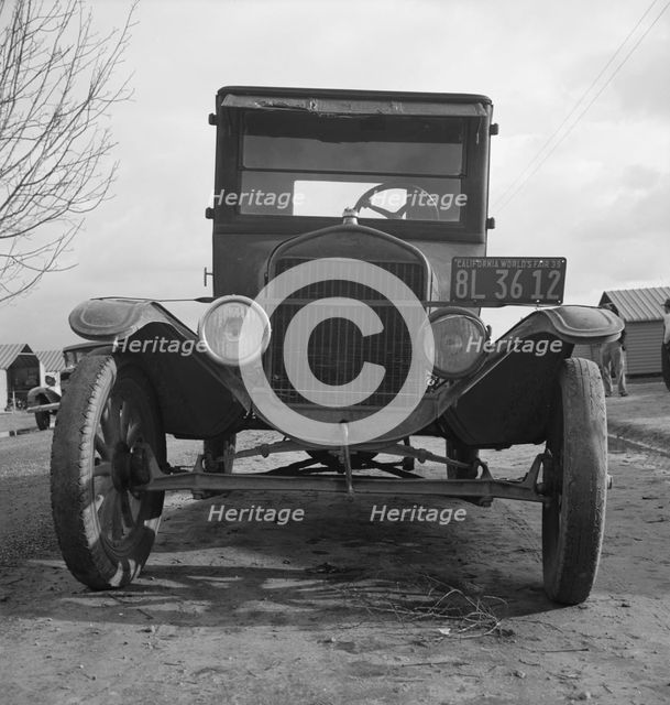 Model T Fords still carry migrants, FSA migratory labor camp at Farmersville, California , 1939. Creator: Dorothea Lange.