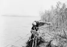 Mohave woman carrying water on her head and holding child, c1903. Creator: Edward Sheriff Curtis