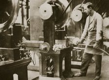Money making; cutting strips of silver into disks, 20th century. Creator: Unknown