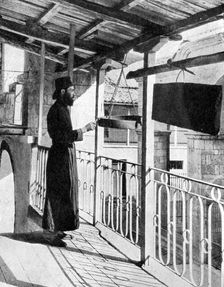 Monk sounding the call to prayer on a gong, Greece, 1936.Artist: Nomias