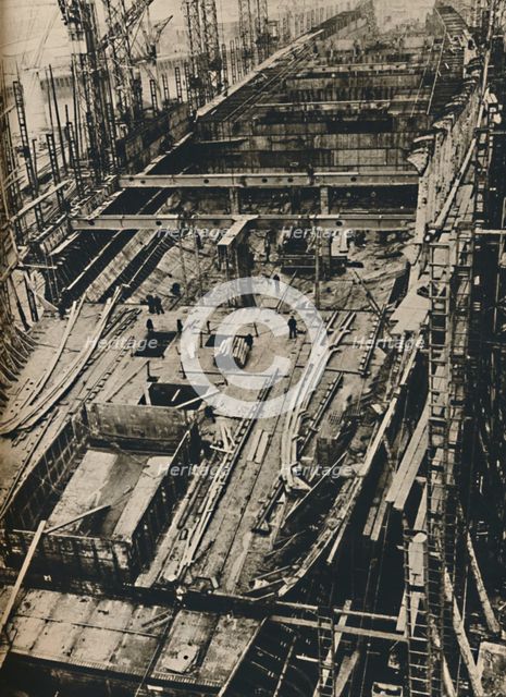 'More than 1,000 Feet Long. Shell of Queen Mary in early days of construction',  1930-1934, (1936). Artist: Unknown.