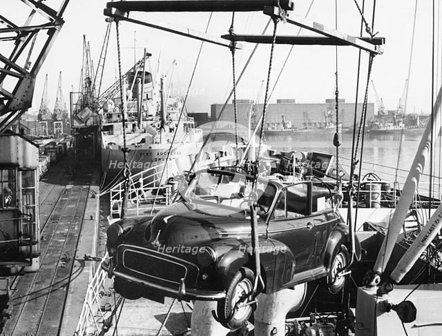 Morris Minor convertible craned onto ship for export at Cardiff docks. Creator: Unknown.