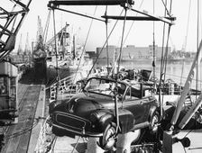 Morris Minor convertible craned onto ship for export at Cardiff docks. Creator: Unknown