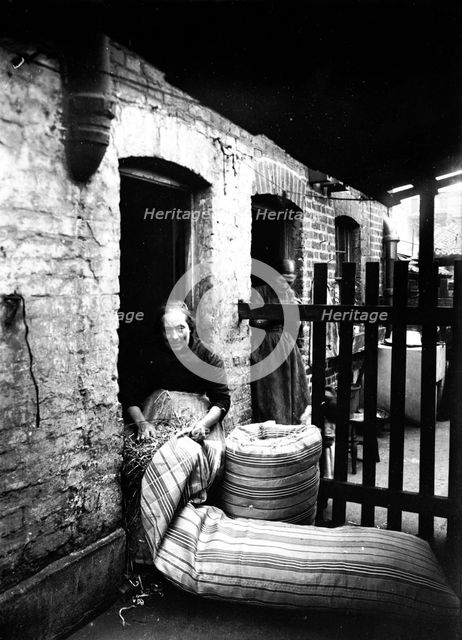 Ma Rolinson of Bethnal Green making mattresses, c1890-c1907. Creator: Unknown.