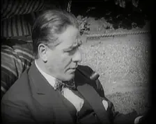 Matheson Lang Relaxing in a Deck Chair Smoking a Pipe, 1920s. Creator: British Pathe Ltd