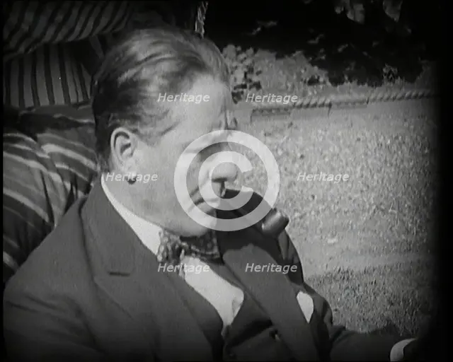 Matheson Lang Relaxing in a Deck Chair Smoking a Pipe, 1920s. Creator: British Pathe Ltd.