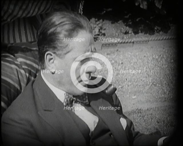 Matheson Lang Relaxing in a Deck Chair Smoking a Pipe, 1920s. Creator: British Pathe Ltd.