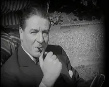 Matheson Lang Relaxing in a Deck Chair Smoking a Pipe, 1920s. Creator: British Pathe Ltd