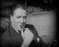 Matheson Lang Relaxing in a Deck Chair Smoking a Pipe, 1920s. Creator: British Pathe Ltd